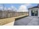 Backyard featuring concrete patio and grassy area with a tree line in the distance at 108 Ellsworth Rd # 40, Mooresville, NC 28115