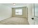 Bright bedroom with neutral walls, plush carpet, and a window with white blinds at 108 Ellsworth Rd # 40, Mooresville, NC 28115