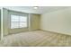 Spacious bedroom with beige walls, carpet flooring, and a bright window with blinds at 108 Ellsworth Rd # 40, Mooresville, NC 28115