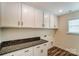 Laundry room features countertop, white cabinets and wood-look flooring at 108 Ellsworth Rd # 40, Mooresville, NC 28115