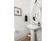 Modern powder room featuring a pedestal sink, round mirror and decorative accents at 1108 Wesley Terrace Ave, Charlotte, NC 28208