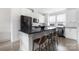 Bright kitchen with white cabinets, a dark island with seating, and stainless steel appliances at 1108 Wesley Terrace Ave, Charlotte, NC 28208