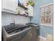 Bright laundry room with modern washer and dryer, complemented by white cabinets and shelving at 1245 Periwinkle Dr, Waxhaw, NC 28173