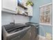 Clean laundry room features a washer, a dryer, storage shelves, and a bright window for natural light at 1245 Periwinkle Dr, Waxhaw, NC 28173