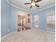 Bright living room features neutral carpet, a ceiling fan, crown molding, and two bright windows for lots of natural light at 1245 Periwinkle Dr, Waxhaw, NC 28173