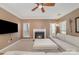 Comfortable living room boasts neutral carpet, a ceiling fan, a fireplace, and a large sofa for relaxing and entertaining at 1245 Periwinkle Dr, Waxhaw, NC 28173