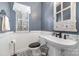 Stylish powder room featuring a pedestal sink, decorative mirror, and black and white patterned flooring at 1245 Periwinkle Dr, Waxhaw, NC 28173