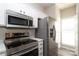 Well-equipped kitchen with stainless steel appliances, modern white cabinets and a bright window at 14713 Lions Pride Ct, Charlotte, NC 28273