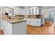 Well-lit kitchen featuring white cabinetry, granite countertops, and hardwood floors at 1511 35Th Ne Ave, Hickory, NC 28601