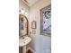 Charming powder room with a pedestal sink, gold framed mirror and decorative artwork at 18845 Cloverstone Cir, Cornelius, NC 28031