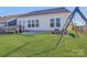 Well-maintained backyard featuring a deck with a grill, patio, green lawn, and a swing set at 19007 Dry Narrows Way, Charlotte, NC 28278