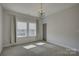 Bright bedroom featuring a stylish chandelier, plush carpeting and large windows with views of the street outside at 19007 Dry Narrows Way, Charlotte, NC 28278