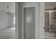 Hallway view showing access to a bedroom with a chandelier and bathroom with tiled shower and sliding glass door at 19007 Dry Narrows Way, Charlotte, NC 28278