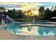 Outdoor community pool with a slide, chairs and umbrellas under a colorful sunset at 19007 Dry Narrows Way, Charlotte, NC 28278