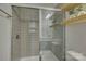 Modern bathroom featuring a tiled shower with glass doors, storage nook and open floating shelves at 19007 Dry Narrows Way, Charlotte, NC 28278