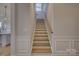 Elegant staircase featuring hardwood steps, white risers, and modern railing for a classic design at 19007 Dry Narrows Way, Charlotte, NC 28278