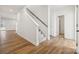 Hallway with hardwood floors and carpeted stairs with wood railing at 2576 Blue Sky Meadows Dr, Monroe, NC 28110