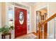 Bright foyer featuring a red front door with oval window, wood floors and staircase at 286 Canvasback Rd, Mooresville, NC 28117