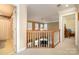 Upstairs hallway featuring white carpet, oak railing, with a glimpse of a two-story living room at 286 Canvasback Rd, Mooresville, NC 28117