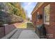 Exterior of brick house with small patio, grassy area, fence and retaining wall at 4008 Saint Andrews Ct, Cramerton, NC 28032
