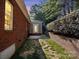 Exterior of brick house with small patio, grassy area, fence and retaining wall at 4008 Saint Andrews Ct, Cramerton, NC 28032
