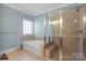 Bathroom featuring soaking tub, walk-in glass shower, and tiled floors at 4008 Saint Andrews Ct, Cramerton, NC 28032