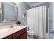 Cozy bathroom with wood vanity, neutral walls, framed mirror, and a shower-tub combination with curtain at 4008 Saint Andrews Ct, Cramerton, NC 28032