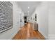 Hallway view with hardwood floors, neutral walls, doors, decorative wall art, and fireplace in the distance at 4008 Saint Andrews Ct, Cramerton, NC 28032