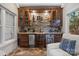 Custom wet bar with a stone backsplash, unique barrel design, mini-fridges, and built-in lighting for entertaining at 4008 Saint Andrews Ct, Cramerton, NC 28032