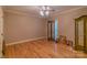 Bedroom with hardwood floors, neutral walls, ceiling fan, and a decorative glass cabinet at 406 Forest Dr, York, SC 29745