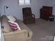 Cozy living room features a plush sofa, accent chair, and classic wooden dresser at 6434 Miller Rd, Kannapolis, NC 28081