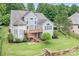 Expansive backyard with a tiered deck, stone retaining walls, and lush landscaping, creating a private oasis at 7191 Grist Mill Ct, Denver, NC 28037