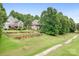 Well-maintained backyard with lush grass, fenced yard, and mature trees overlooking the golf course at 7191 Grist Mill Ct, Denver, NC 28037