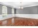 Formal dining room with hardwood floors, decorative wainscoting, chandelier and large arched windows at 7191 Grist Mill Ct, Denver, NC 28037