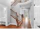 Grand entryway features hardwood floors, staircase with wood and iron details, and views into the living room at 7191 Grist Mill Ct, Denver, NC 28037