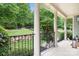 Picturesque front porch featuring classic columns, wrought iron railings, and a serene view of the landscaped yard at 7191 Grist Mill Ct, Denver, NC 28037