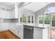 Bright kitchen featuring white cabinetry, a farmhouse sink, and expansive countertops at 7191 Grist Mill Ct, Denver, NC 28037