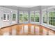 Bright sunroom features hardwood flooring and windows overlooking the lush backyard and outdoor deck at 7191 Grist Mill Ct, Denver, NC 28037