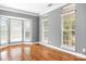 Sun-filled living room features hardwood floors, neutral paint, and large windows offering great natural light at 7191 Grist Mill Ct, Denver, NC 28037