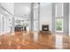 Open-concept living area with a stone fireplace, hardwood floors, and views of the kitchen and breakfast bar at 7191 Grist Mill Ct, Denver, NC 28037