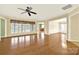 Bright living room with ceiling fan, fireplace, hardwood floors, and view to kitchen at 7203 Shenandoah Dr, Fort Mill, SC 29707