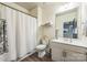 Well-lit bathroom featuring modern fixtures, vanity storage, and a shower with a white curtain at 8008 Breckenhill Ln, Tega Cay, SC 29708