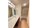 Bathroom features long vanity with a large mirror and sconce lighting adjacent to a tub with shower at 8471 Penton Pl, Harrisburg, NC 28075