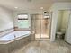 Luxurious bathroom featuring a soaking tub, glass-enclosed shower, and tiled floors at 8471 Penton Pl, Harrisburg, NC 28075