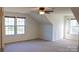 Bedroom with multiple windows, carpet, and unique wall design, providing natural light and character at 8471 Penton Pl, Harrisburg, NC 28075