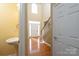 Inviting foyer with hardwood floors, a staircase, and a pedestal sink in the foreground at 8471 Penton Pl, Harrisburg, NC 28075