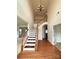 Bright foyer with hardwood floors, staircase and chandelier, creating an inviting entry at 8471 Penton Pl, Harrisburg, NC 28075