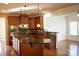 Spacious kitchen with an island, wooden cabinets, stainless steel oven, and dark granite countertops at 8471 Penton Pl, Harrisburg, NC 28075