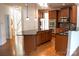Modern kitchen with granite countertops, stainless steel appliances, wooden cabinets, and hardwood floors at 8471 Penton Pl, Harrisburg, NC 28075