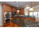 Kitchen with stainless steel appliances, wood cabinets, granite counters and island with eating space at 8471 Penton Pl, Harrisburg, NC 28075